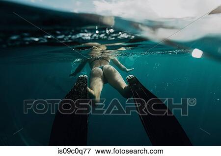 Stock Photo - Woman swimming underwater. Fotosearch