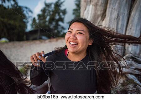 Stock Image - Woman swinging hair, Kailua Beach, Oahu, Hawaii. Fotosearch