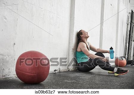 Woman taking break in cross training gym View Large Photo Image Stock Photo - Woman taking break in cross training gym. Fotosearch