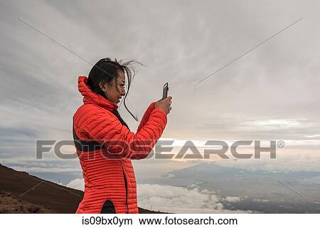Picture - Woman taking photograph, Haleakala National Park, Maui, Hawaii. Fotosearch
