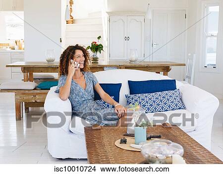 Woman talking on cellphone on sofa View Large Photo Image Picture - Woman talking on cellphone on sofa. Fotosearch