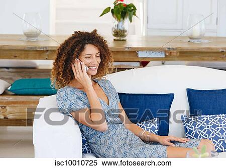Woman talking on cellphone on sofa View Large Photo Image Stock Photography - Woman talking on cellphone on sofa. Fotosearch