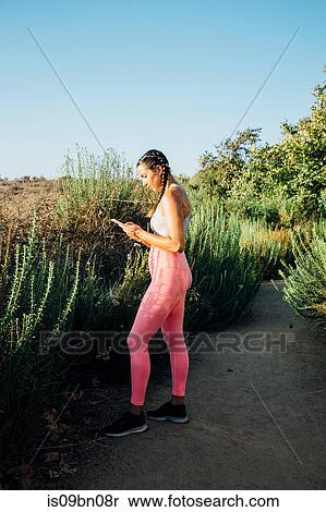 Woman texting among shrubs View Large Photo Image Stock Photography - Woman texting among shrubs. Fotosearch