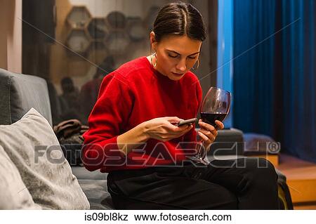 Stock Photo - Woman texting on mobile phone while at party. Fotosearch