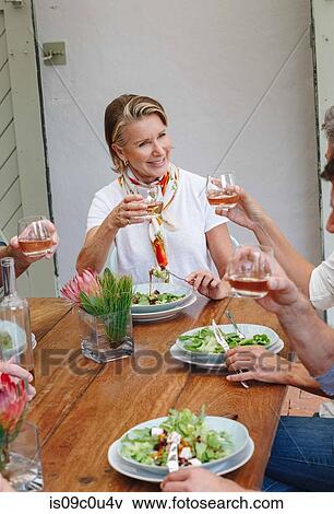 Woman toasting at lunch with friends in restaurant View Large Photo Image Stock Photo - Woman toasting at lunch with friends in restaurant. Fotosearch