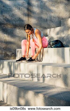 Woman tying trainer laces on steps View Large Photo Image Stock Photograph - Woman tying trainer laces on steps. Fotosearch