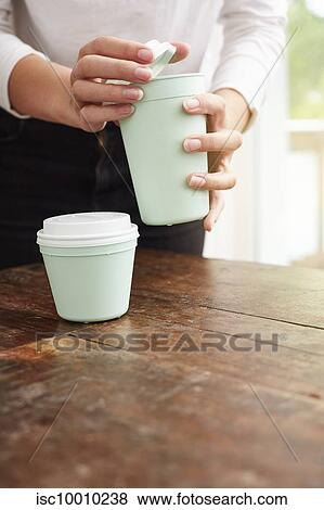 Stock Photo - Woman using reusable coffee cup. Fotosearch