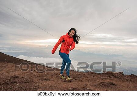 Woman walking along edge of mountain, Haleakala National Park, Maui, Hawaii View Large Photo Image Stock Image - Woman walking along edge of mountain, Haleakala National Park, Maui, Hawaii. Fotosearch