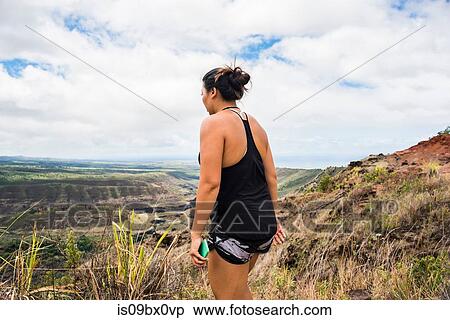Woman walking with cellphone in hand, Waimea Canyon, Kauai, Hawaii View Large Photo Image Stock Photography - Woman walking with cellphone in hand, Waimea Canyon, Kauai, Hawaii. Fotosearch