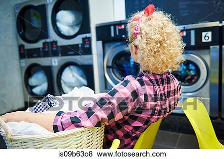 Woman watching washing machines in laundrette View Large Photo Image Stock Photo - Woman watching washing machines in laundrette. Fotosearch