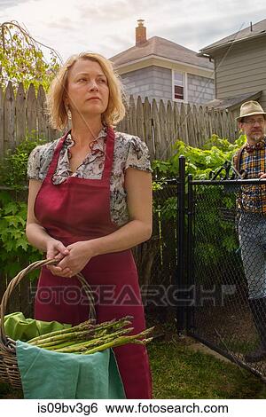 Woman with basket of asparagus and husband distracted in garden View Large Photo Image Stock Photograph - Woman with basket of asparagus and husband distracted in garden. Fotosearch