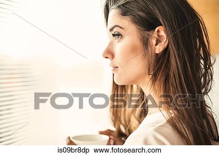 Woman with cup contemplating by window View Large Photo Image Stock Photography - Woman with cup contemplating by window. Fotosearch