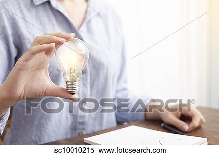 Woman with electric bulb planning how to save energy and money View Large Photo Image Stock Photography - Woman with electric bulb planning how to save energy and money. Fotosearch