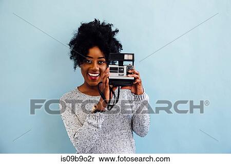 Woman with instant camera looking at camera smiling View Large Photo Image Stock Photography - Woman with instant camera looking at camera smiling. Fotosearch