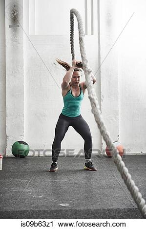 Woman working out with battle rope in cross training gym View Large Photo Image Stock Image - Woman working out with battle rope in cross training gym. Fotosearch