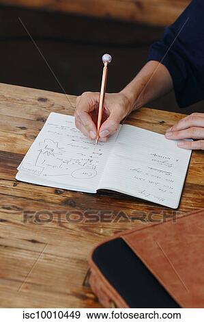 Woman writing in notebook on table top View Large Photo Image Stock Photo - Woman writing in notebook on table top. Fotosearch