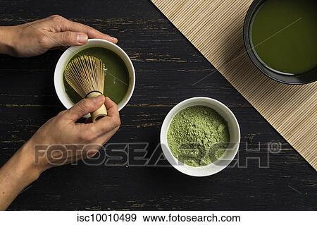 Woman's hands mixing matcha green tea powder in a bowl, overhead view View Large Photo Image Stock Photo - Woman's hands mixing matcha green tea powder in a bowl, overhead view. Fotosearch