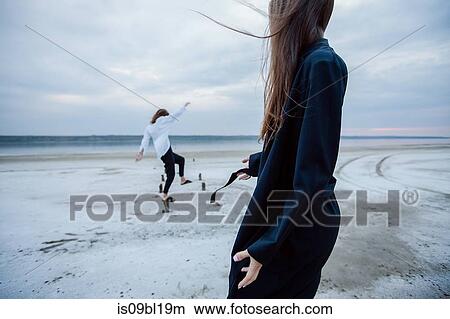 Women balancing on wooden stumps on beach, Odessa, Ukraine View Large Photo Image Picture - Women balancing on wooden stumps on beach, Odessa, Ukraine. Fotosearch