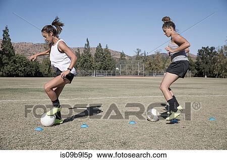 Stock Photography - Women dribbling footballs. Fotosearch