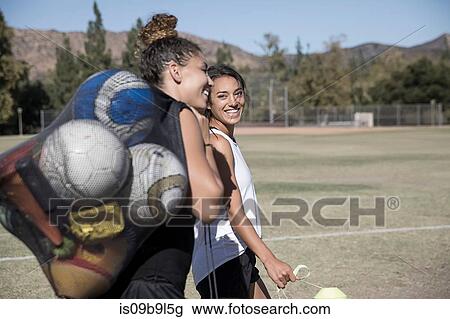 Women on football pitch carrying footballs in net sack View Large Photo Image Stock Image - Women on football pitch carrying footballs in net sack. Fotosearch