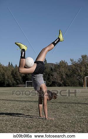 Women on football pitch doing handstand with football View Large Photo Image Stock Image - Women on football pitch doing handstand with football. Fotosearch