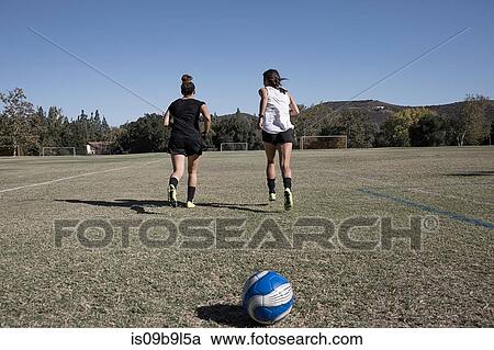 Stock Image - Women on football pitch warming up. Fotosearch