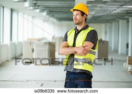Workers wearing hi vis vest, standing in newly constructed office space View Large Photo Image Stock Photography - Workers wearing hi vis vest, standing in newly constructed office space. Fotosearch