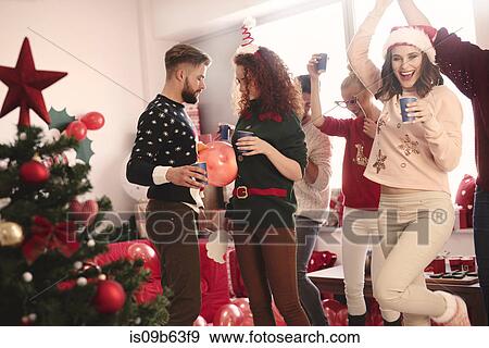 Stock Photo - Young adult friends dancing at christmas party. Fotosearch