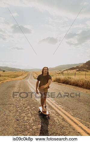 Young barefoot male skateboarder skateboarding on rural road, Exeter, California, USA View Large Photo Image Stock Photography - Young barefoot male skateboarder skateboarding on rural road, Exeter, California, USA. Fotosearch