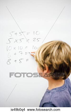Young boy doing sums on whiteboard, rear view View Large Photo Image Picture - Young boy doing sums on whiteboard, rear view. Fotosearch
