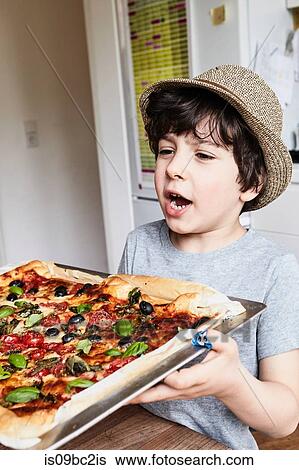 Young boy holding freshly baked pizza View Large Photo Image Stock Photograph - Young boy holding freshly baked pizza. Fotosearch