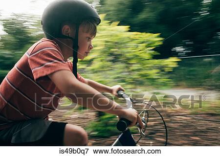 Stock Photo - Young boy riding bicycle outdoors. Fotosearch