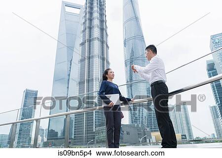 Young businesswoman and man talking in city financial district, Shanghai, China View Large Photo Image Picture - Young businesswoman and man talking in city financial district, Shanghai, China. Fotosearch