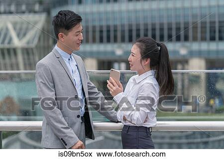 Young businesswoman and man talking in city, Shanghai, China View Large Photo Image Stock Photo - Young businesswoman and man talking in city, Shanghai, China. Fotosearch