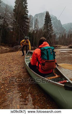 Young canoeing couple pushing off from riverbank, Yosemite Village, California, USA View Large Photo Image Stock Image - Young canoeing couple pushing off from riverbank, Yosemite Village, California, USA. Fotosearch