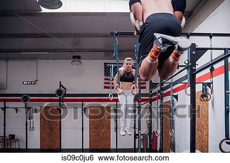 Young couple balancing on gymnastic rings in gym View Large Photo Image Stock Photograph - Young couple balancing on gymnastic rings in gym. Fotosearch