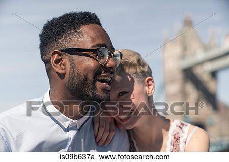 Young couple laughing together outdoors, Tower Bridge in background, London, England, UK View Large Photo Image Stock Image - Young couple laughing together outdoors, Tower Bridge in background, London, England, UK. Fotosearch
