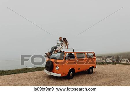 Young couple on top of recreational vehicle at coastal roadside, Jalama, California, USA View Large Photo Image Stock Photo - Young couple on top of recreational vehicle at coastal roadside, Jalama, California, USA. Fotosearch