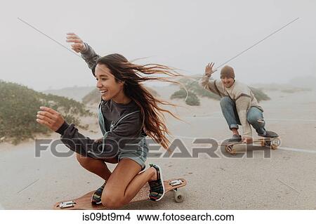 Young couple skateboarding in misty beach carpark, Jalama, California, USA View Large Photo Image Picture - Young couple skateboarding in misty beach carpark, Jalama, California, USA. Fotosearch