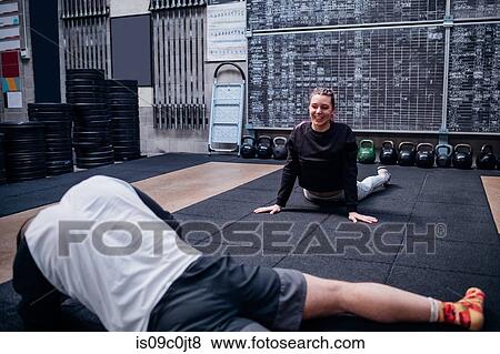 Stock Photo - Young couple stretching in gym. Fotosearch