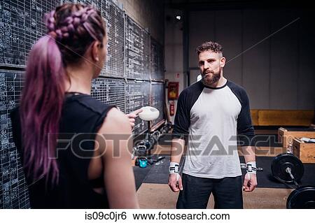 Young couple talking in gym View Large Photo Image Stock Photograph - Young couple talking in gym. Fotosearch
