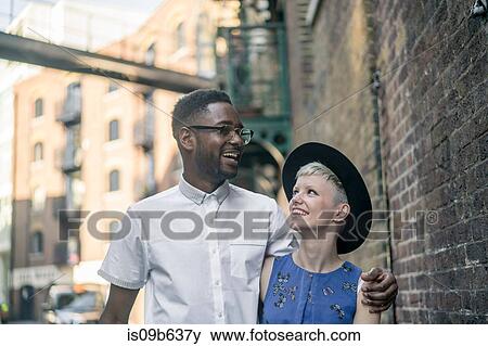 Young couple walking along street, smiling View Large Photo Image Stock Photo - Young couple walking along street, smiling. Fotosearch