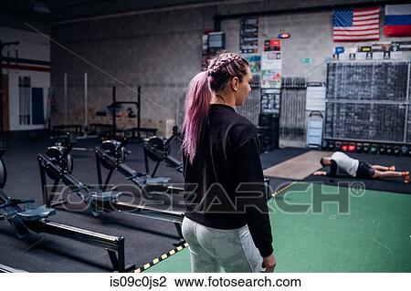 Stock Image - Young couple working out in gym. Fotosearch