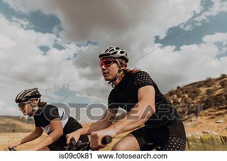 Young cycling couple cycling on rural road, side view, Exeter, California, USA View Large Photo Image Stock Image - Young cycling couple cycling on rural road, side view, Exeter, California, USA. Fotosearch