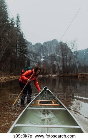 Young female canoeist pulling canoe in river, Yosemite Village, California, USA View Large Photo Image Stock Photography - Young female canoeist pulling canoe in river, Yosemite Village, California, USA. Fotosearch