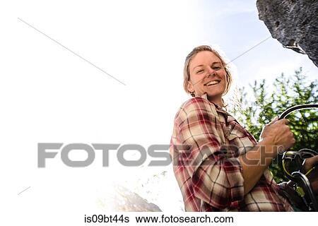 Stock Photograph - Young female rock climber at rock face, portrait, Smoke Bluffs, Squamish, British Columbia, Canada. Fotosearch