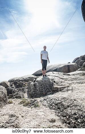 Young female runner taking a break on beach rocks, full length, Cape Town, Western Cape, South Africa View Large Photo Image Stock Photo - Young female runner taking a break on beach rocks, full length, Cape Town, Western Cape, South Africa. Fotosearch
