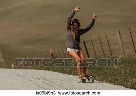 Young female skateboarder skateboarding on rural road, Jalama, California, USA View Large Photo Image Stock Image - Young female skateboarder skateboarding on rural road, Jalama, California, USA. Fotosearch