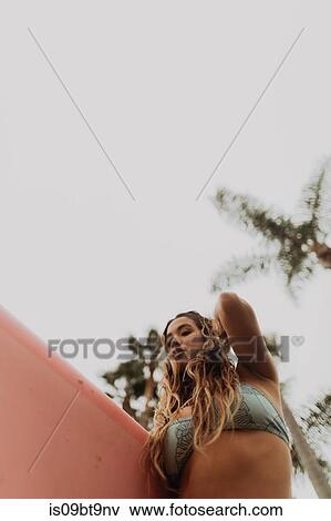 Young female surfer carrying surfboard at beach, low angle view, Ventura, California, USA View Large Photo Image Stock Photo - Young female surfer carrying surfboard at beach, low angle view, Ventura, California, USA. Fotosearch