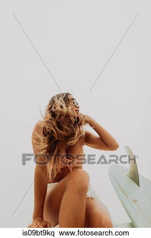 Stock Photography - Young female surfer in bikini at beach, Jalama, California, USA. Fotosearch